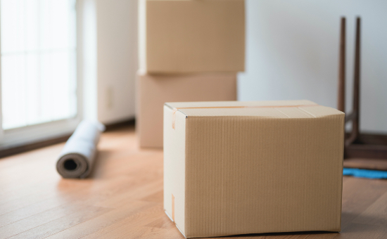 引っ越しのの荷物を詰めた段ボールと片付いた部屋